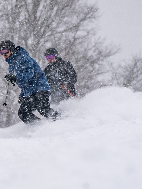 skiers riding in a snow storm