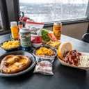 Spread of food at the Eagle's Nest showing sandwiches, chili, mac and cheese, soft pretzels, and beer.