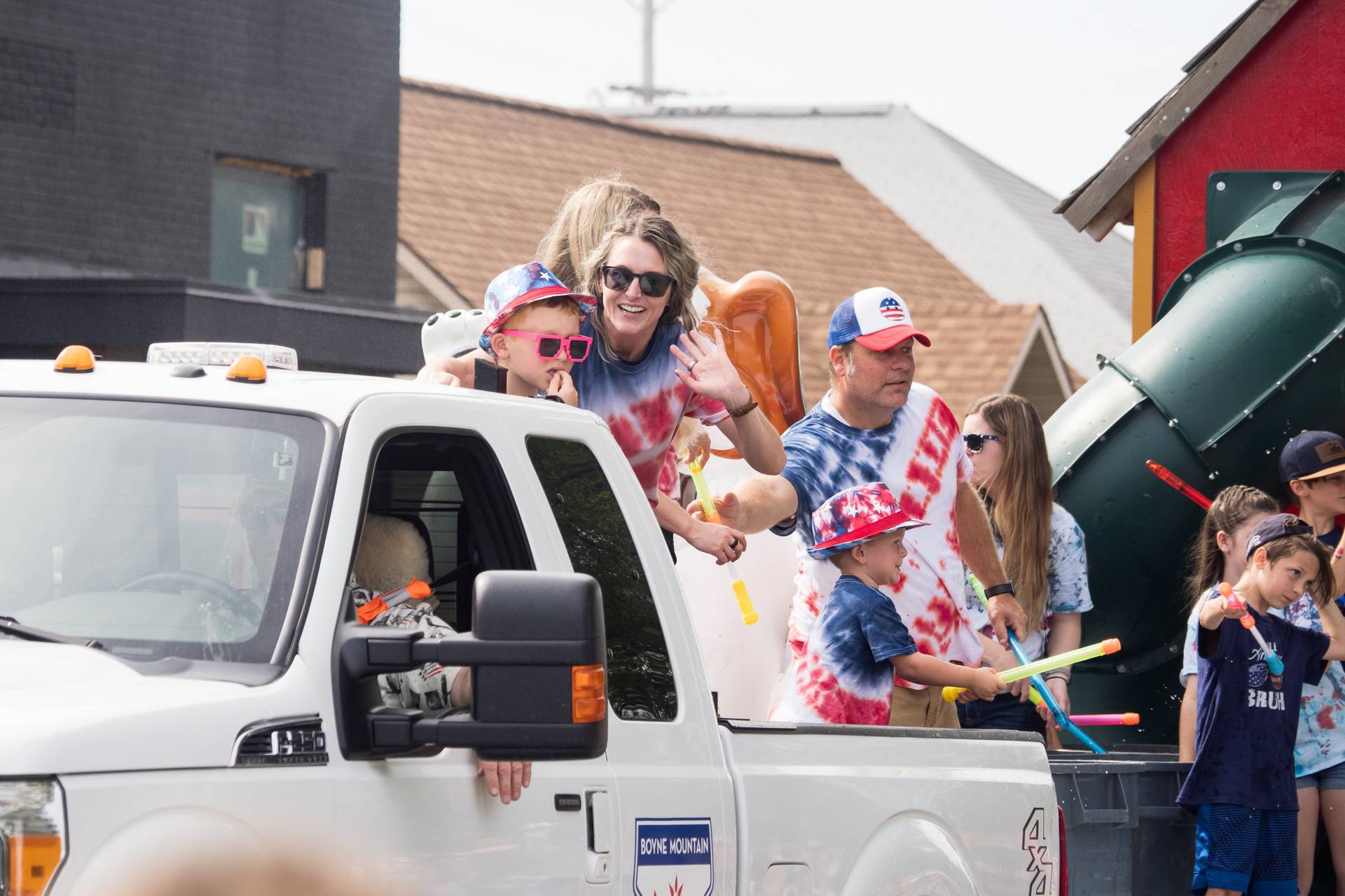 Person with children waving from parade truck