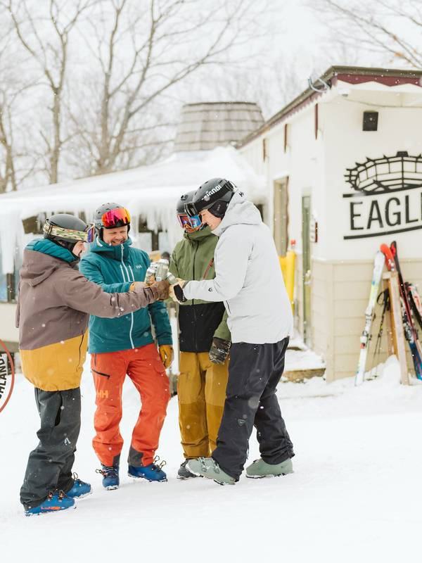 Guys having beers by Eagle's Nest with Mitten Love logo on picture