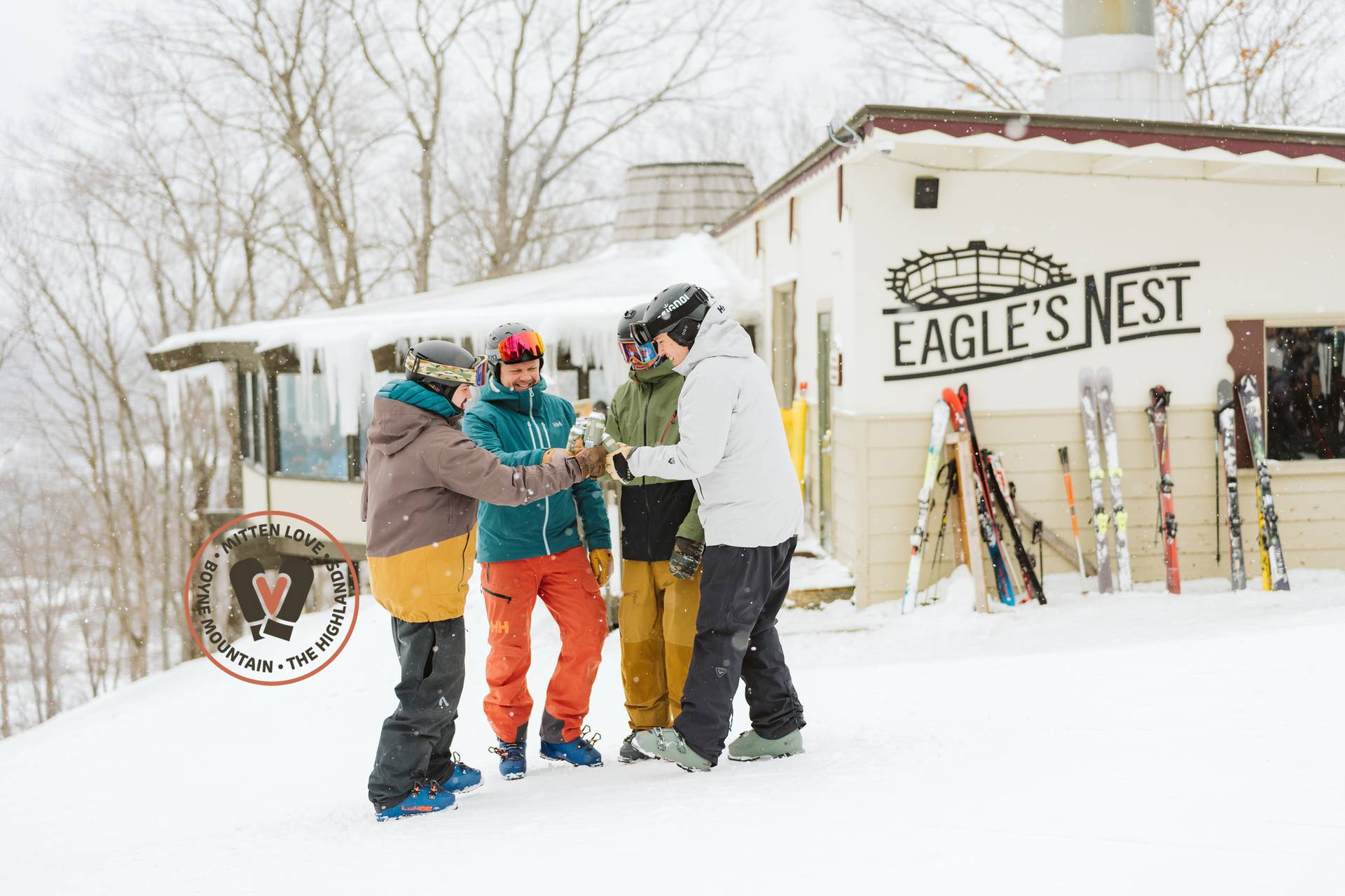 Guys having beers by Eagle's Nest with Mitten Love logo on picture