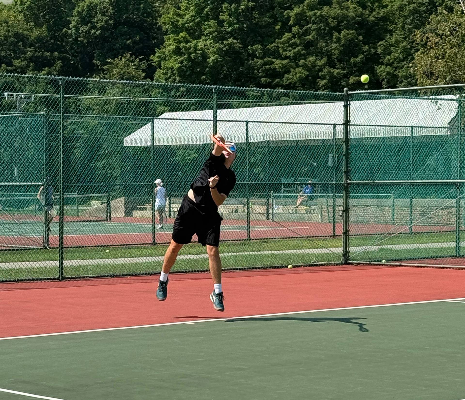 Guy serving a tennis ball