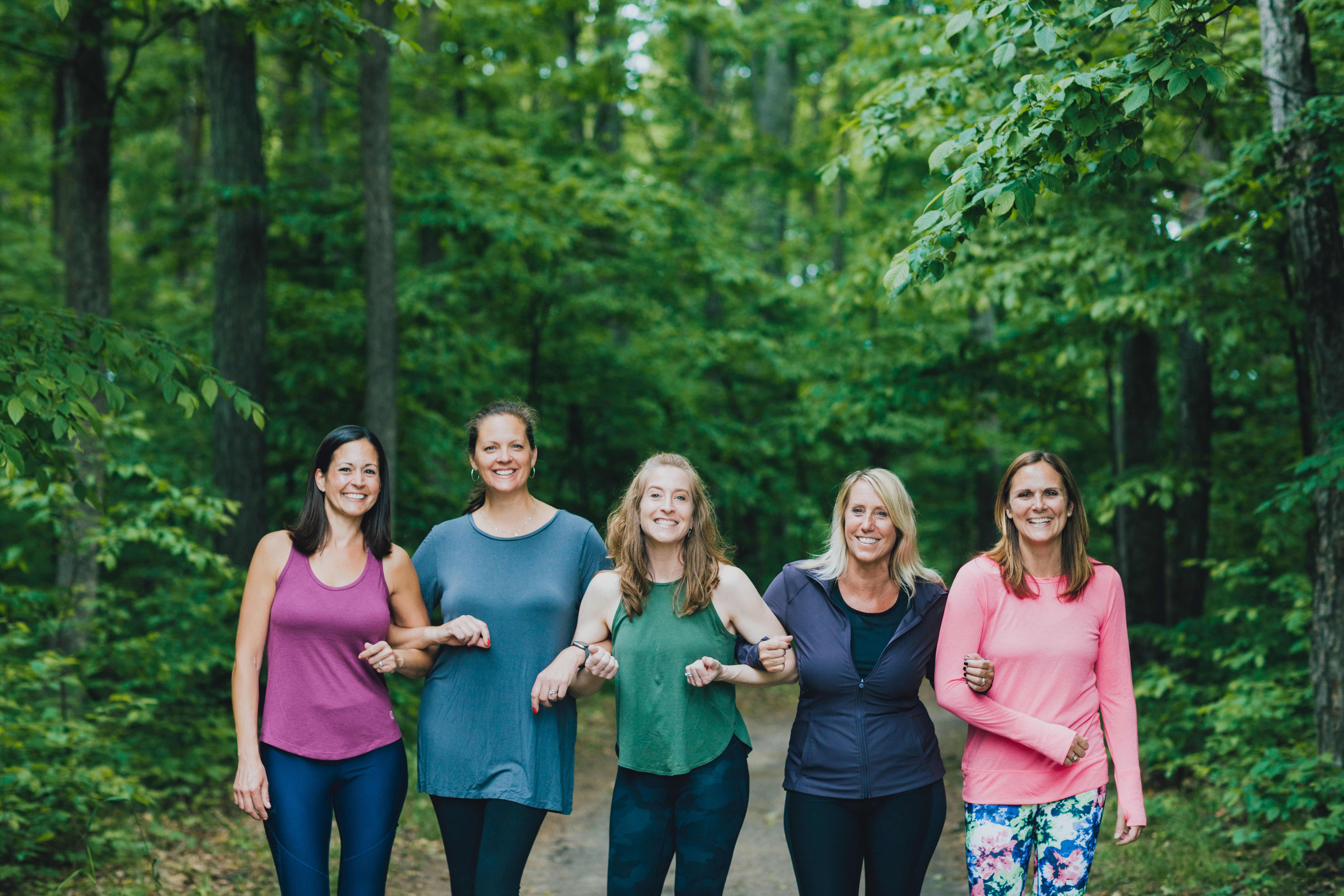 Five ladies locking arms for picture on the paved hiking trail.