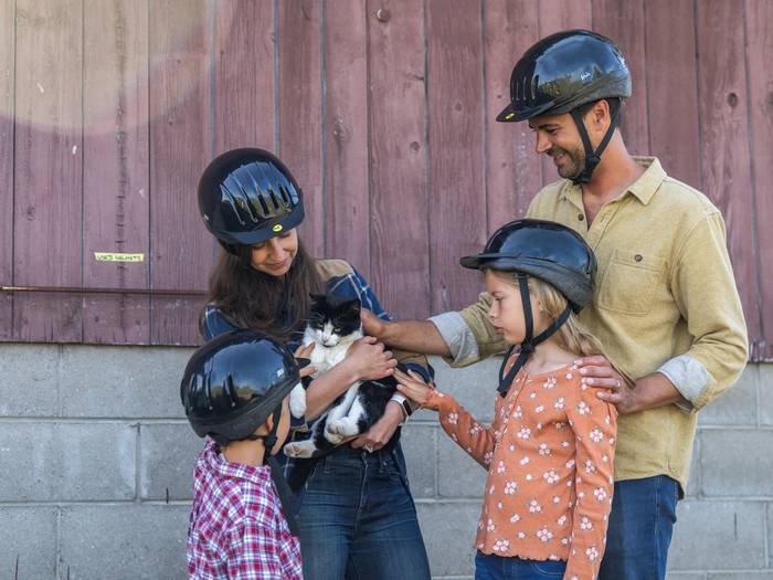 family posing for photo with barn cat