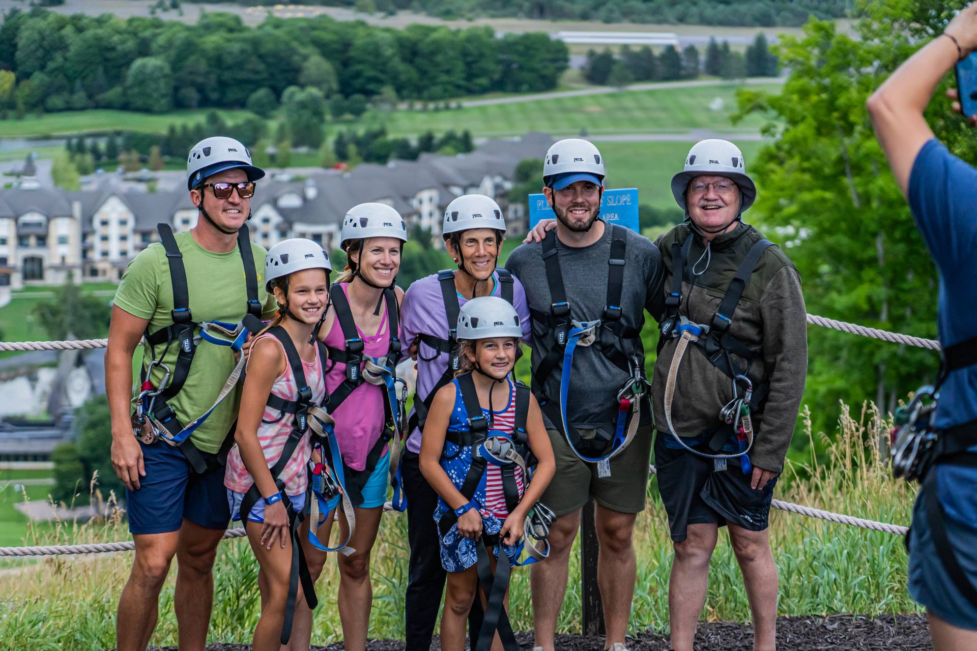 family taking group photo with zipline gear on