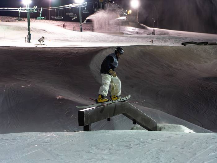 skier hitting rail at night