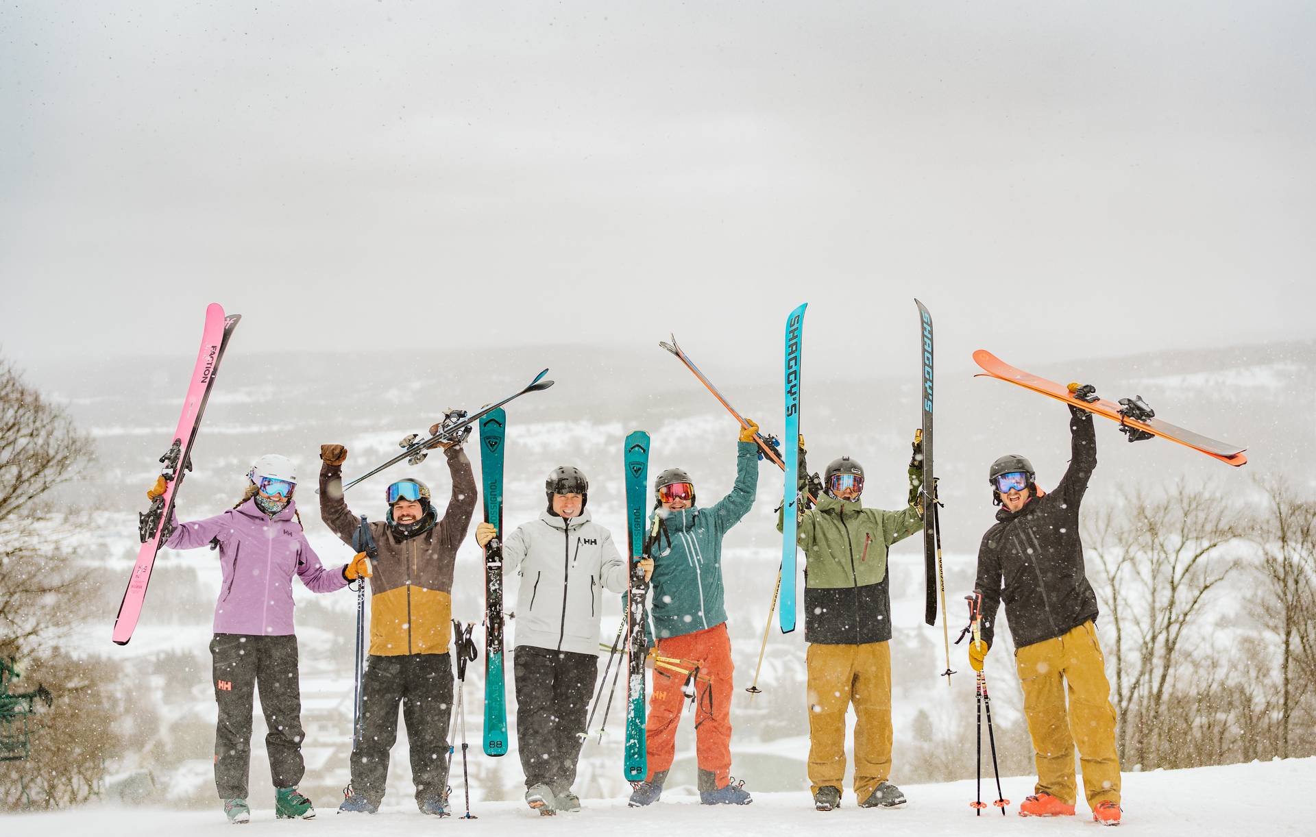 group of skiers holding skis up in the air