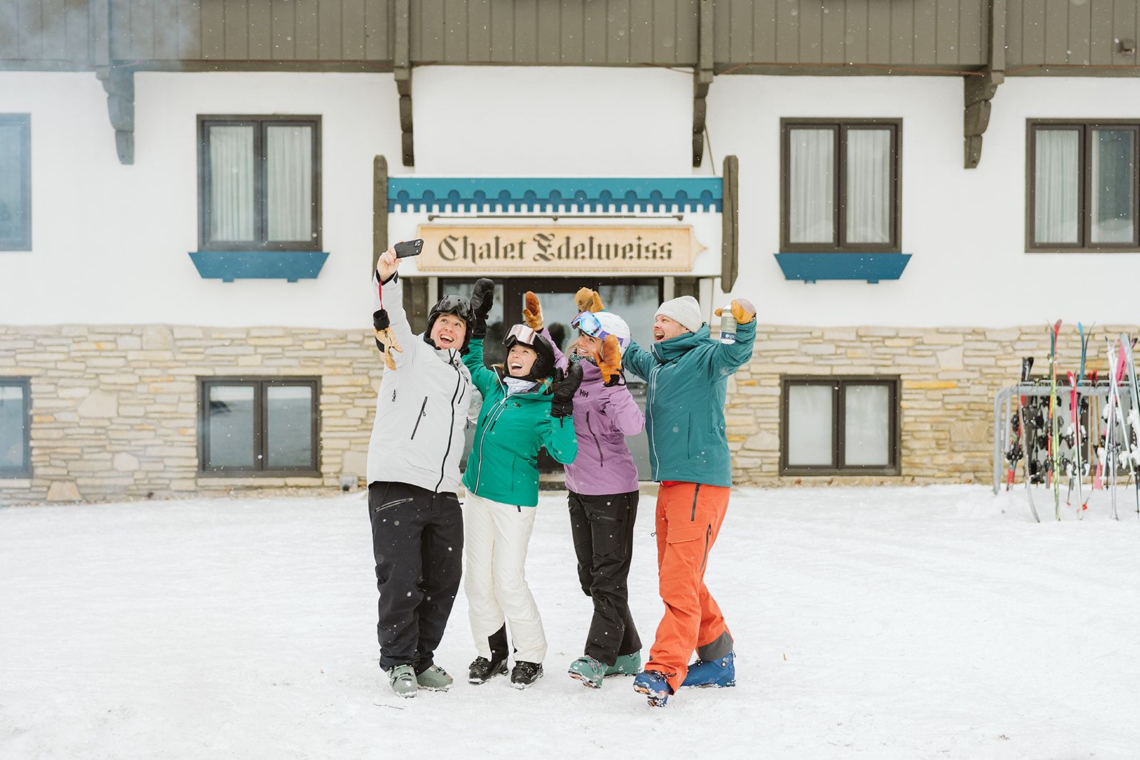 Skiers taking selfie in front of hotel
