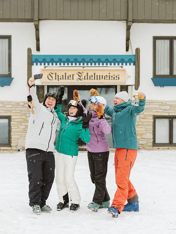 Skiers taking selfie in front of hotel