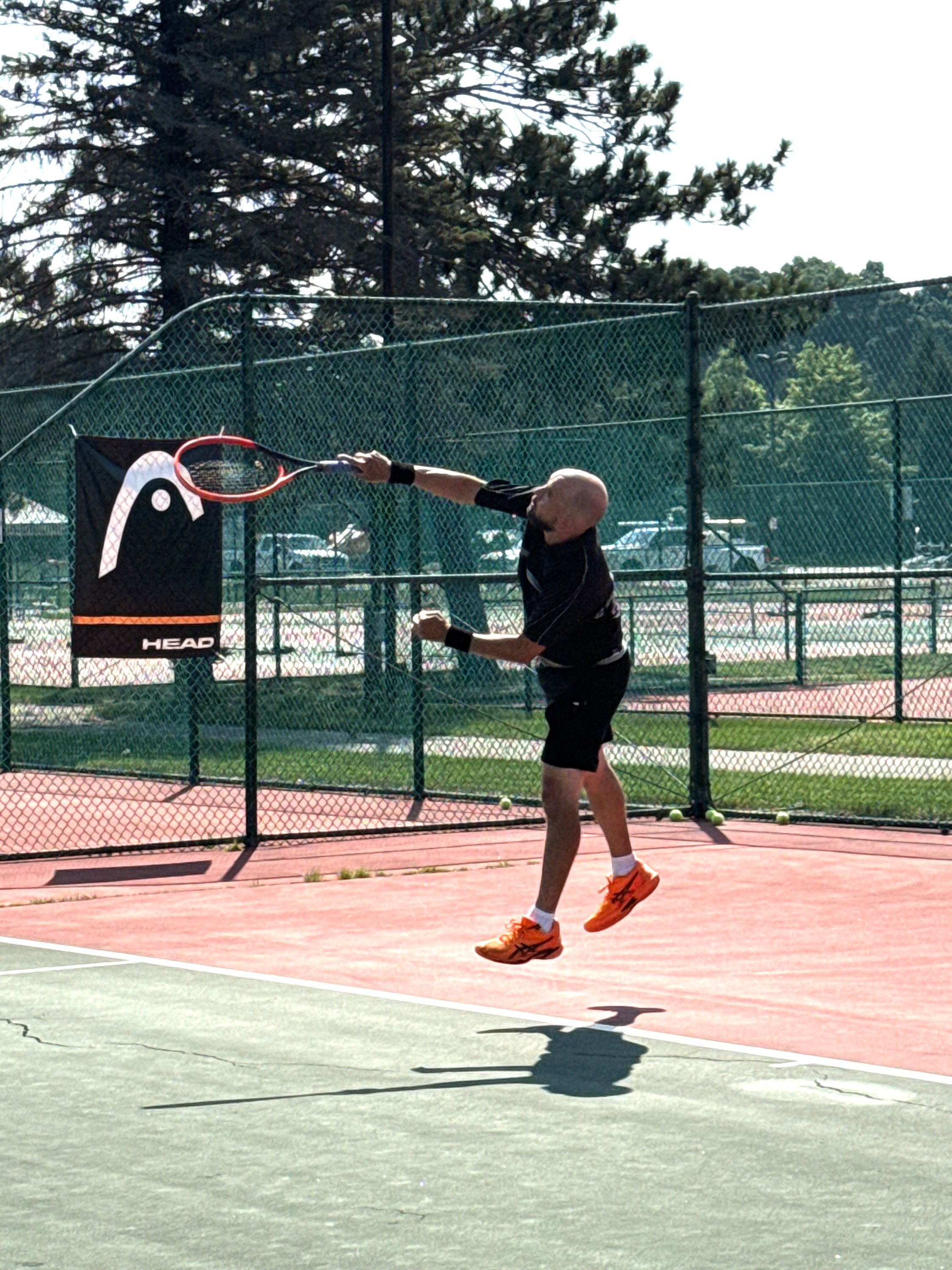 Guy serving the tennis ball