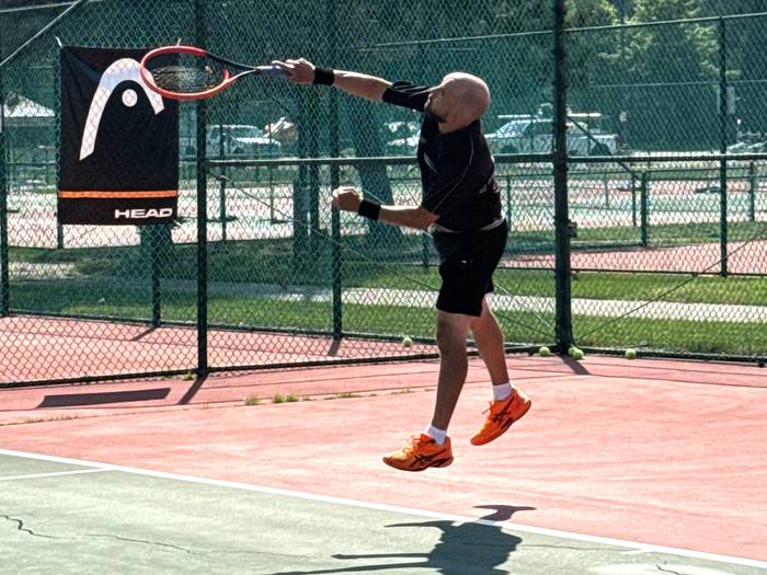 Guy serving the tennis ball