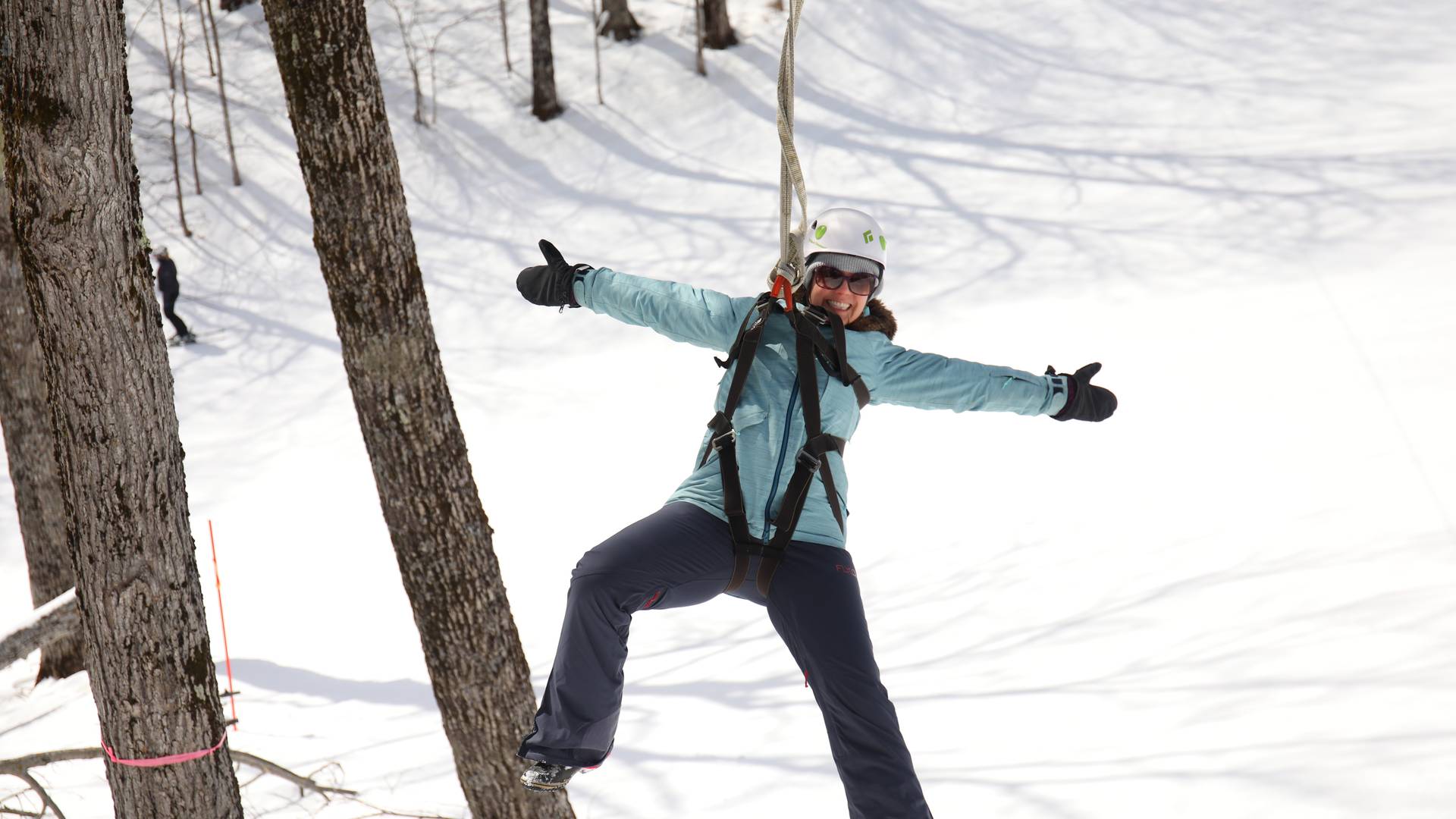 Lady having fun ziplining through the air in the winter