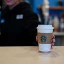 Barista handing over a coffee cup across the counter