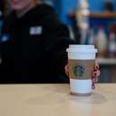 Barista handing over a coffee cup across the counter