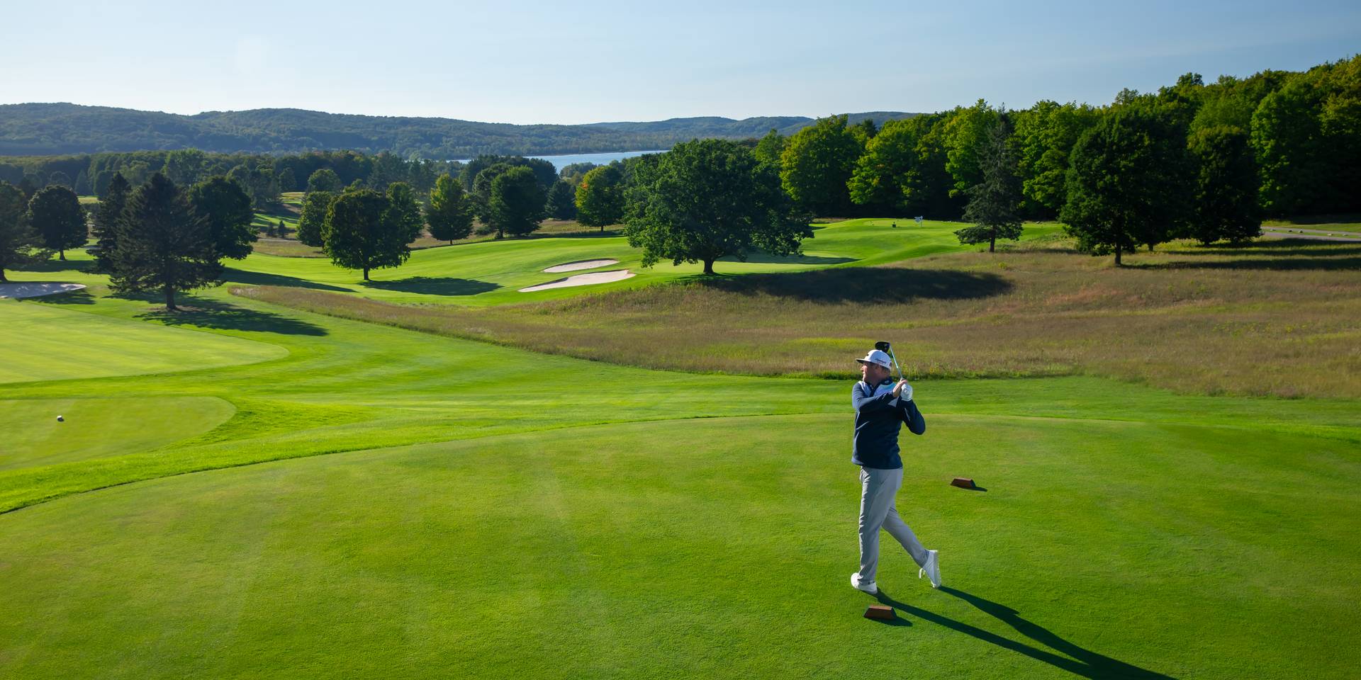 Golfer teeing off on the Alpine