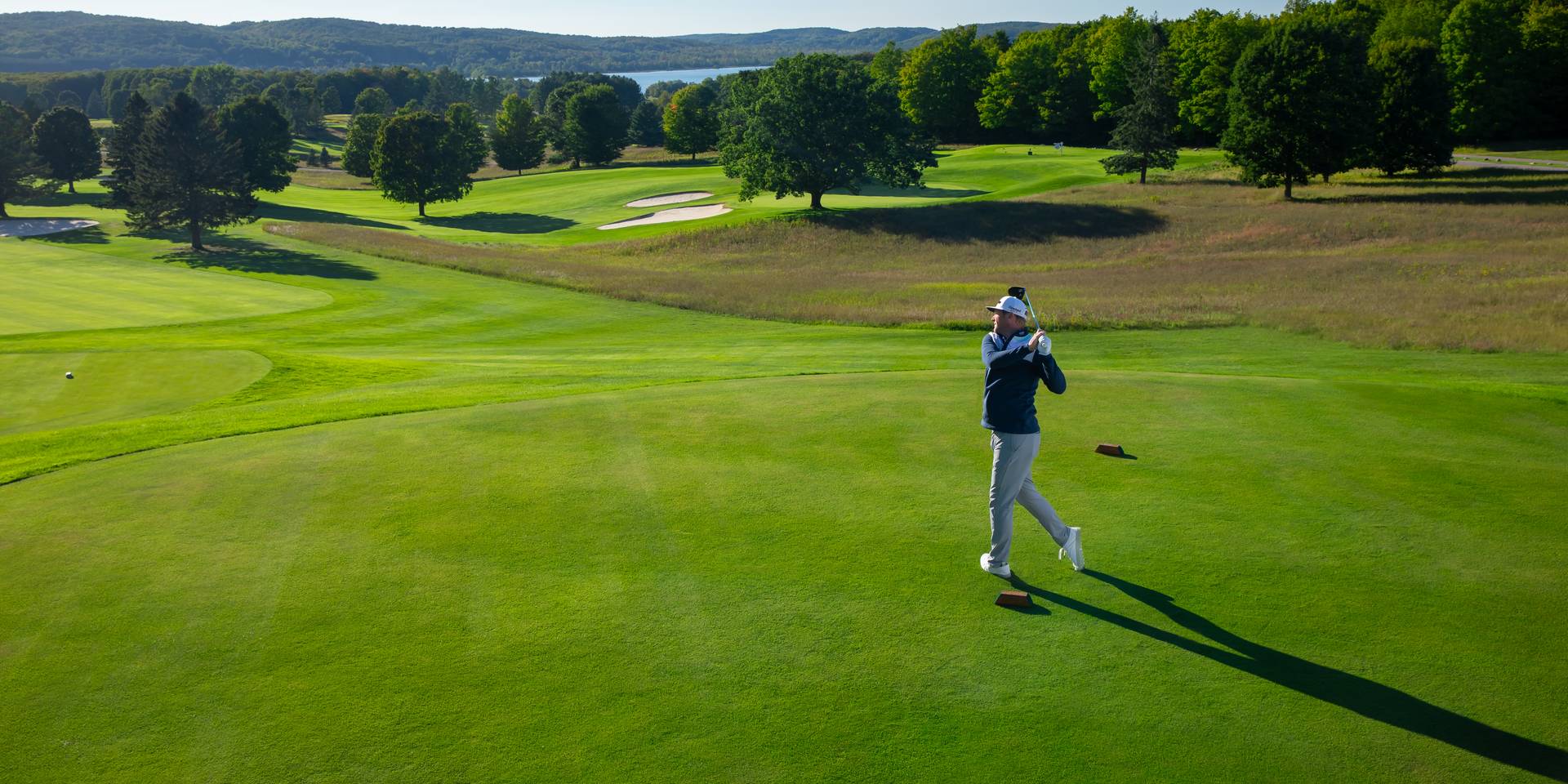 Golfer teeing off on the Alpine