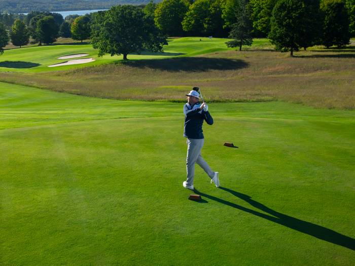 Golfer teeing off on the Alpine