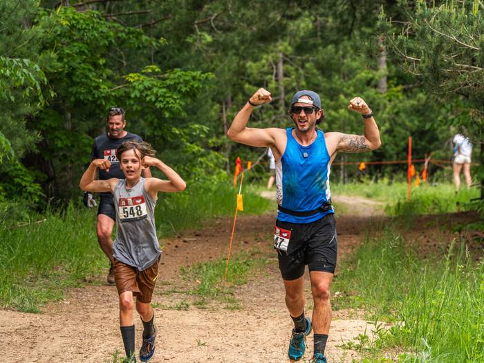 Father and son flexing for the camera while running