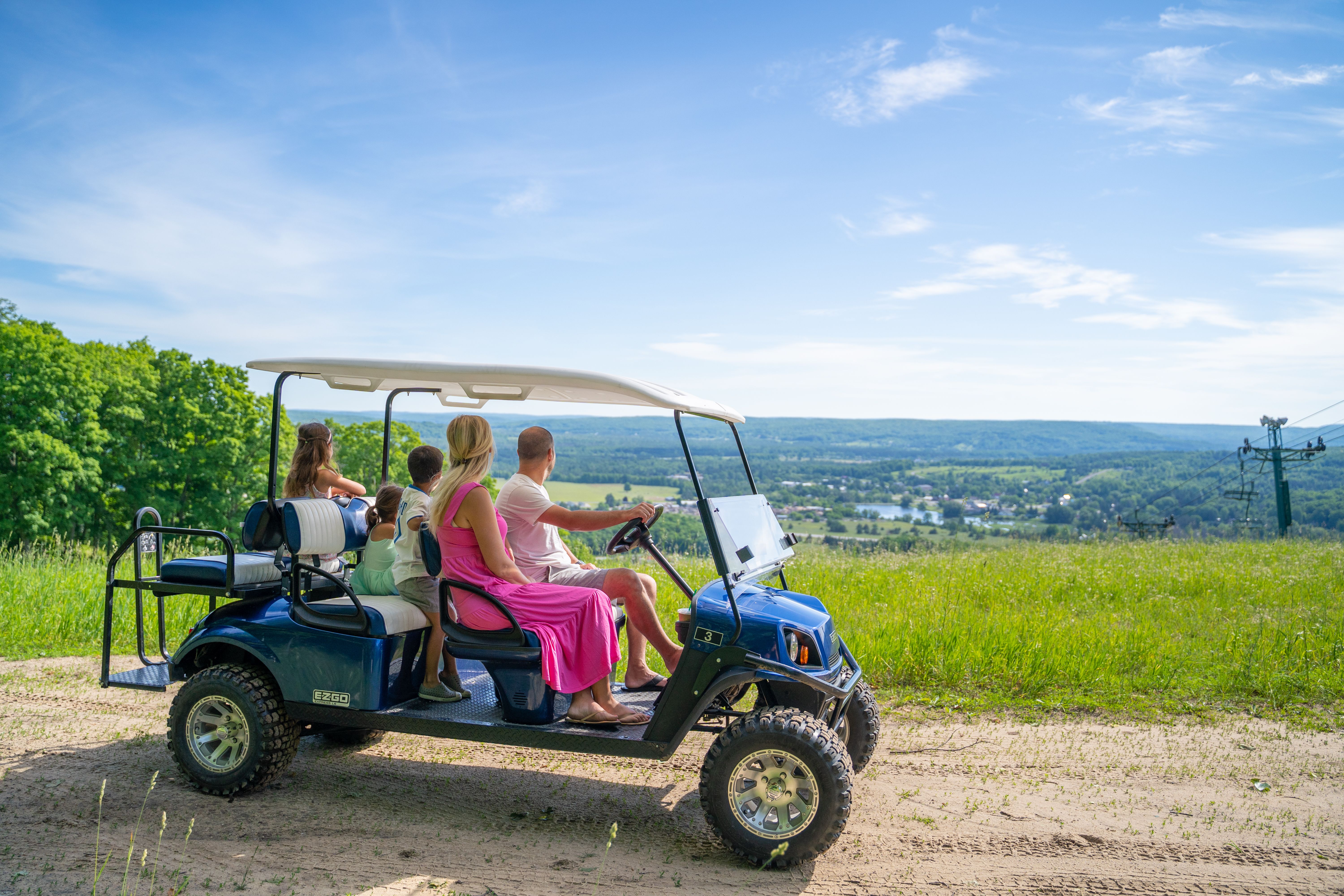 Family on scenic cart viewing down the ski hill from the top.