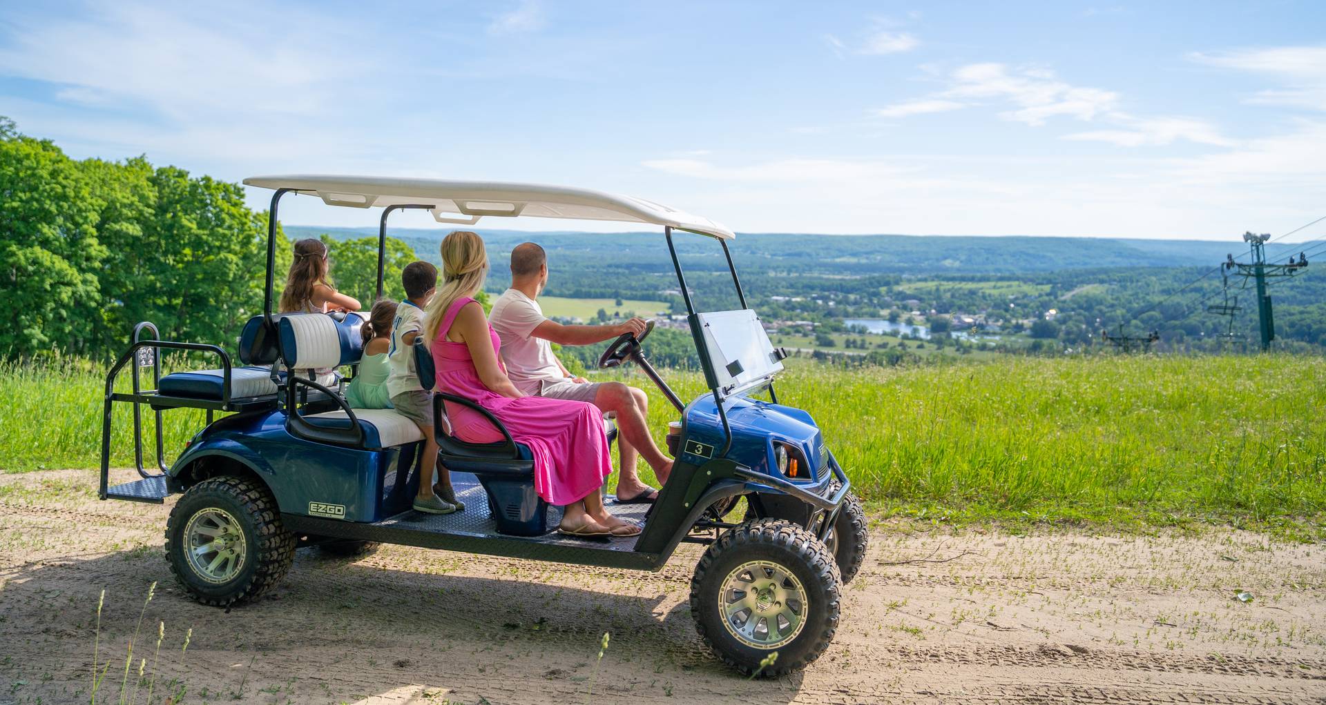 Family on scenic cart viewing down the ski hill from the top.