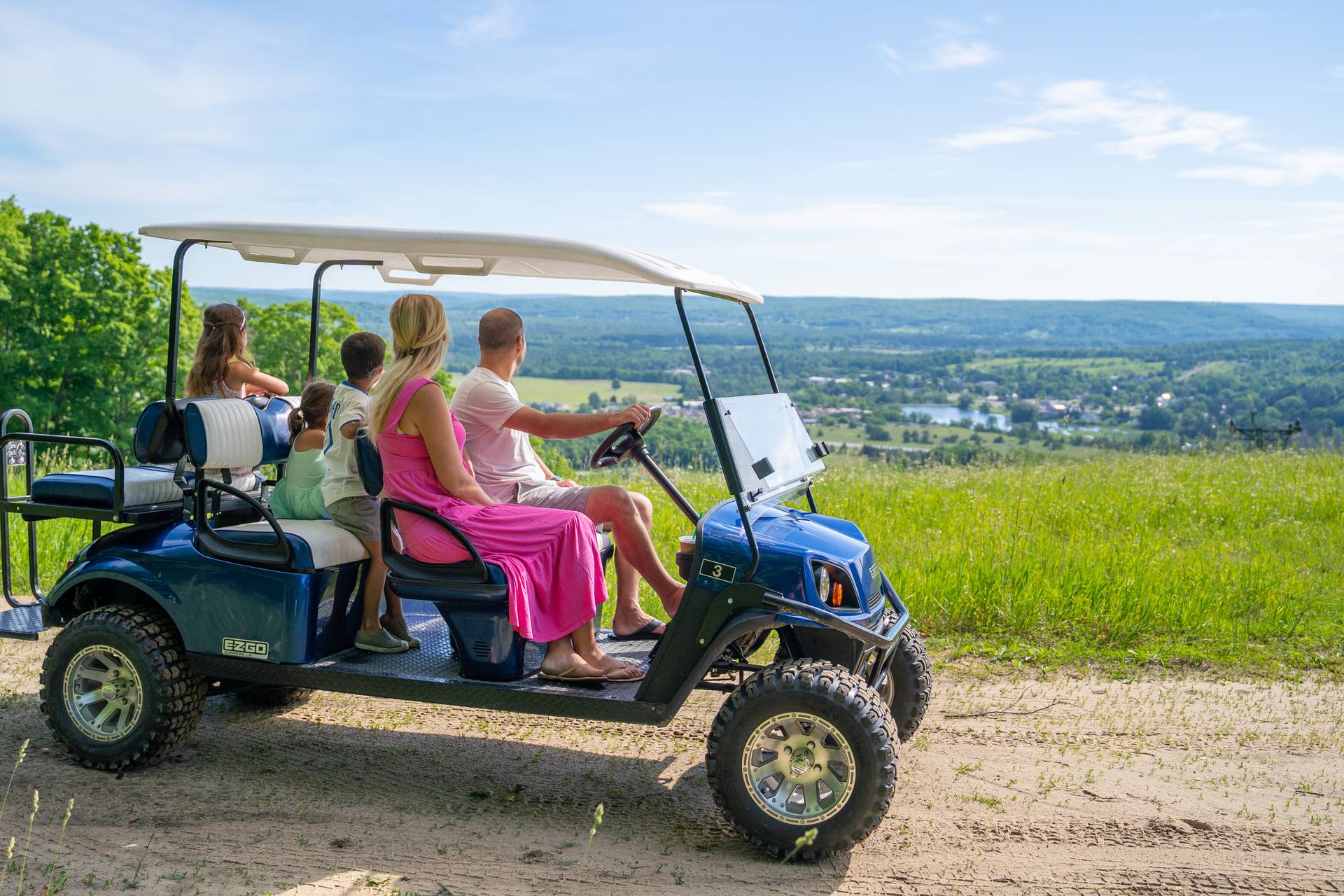 Family on scenic cart viewing down the ski hill from the top.
