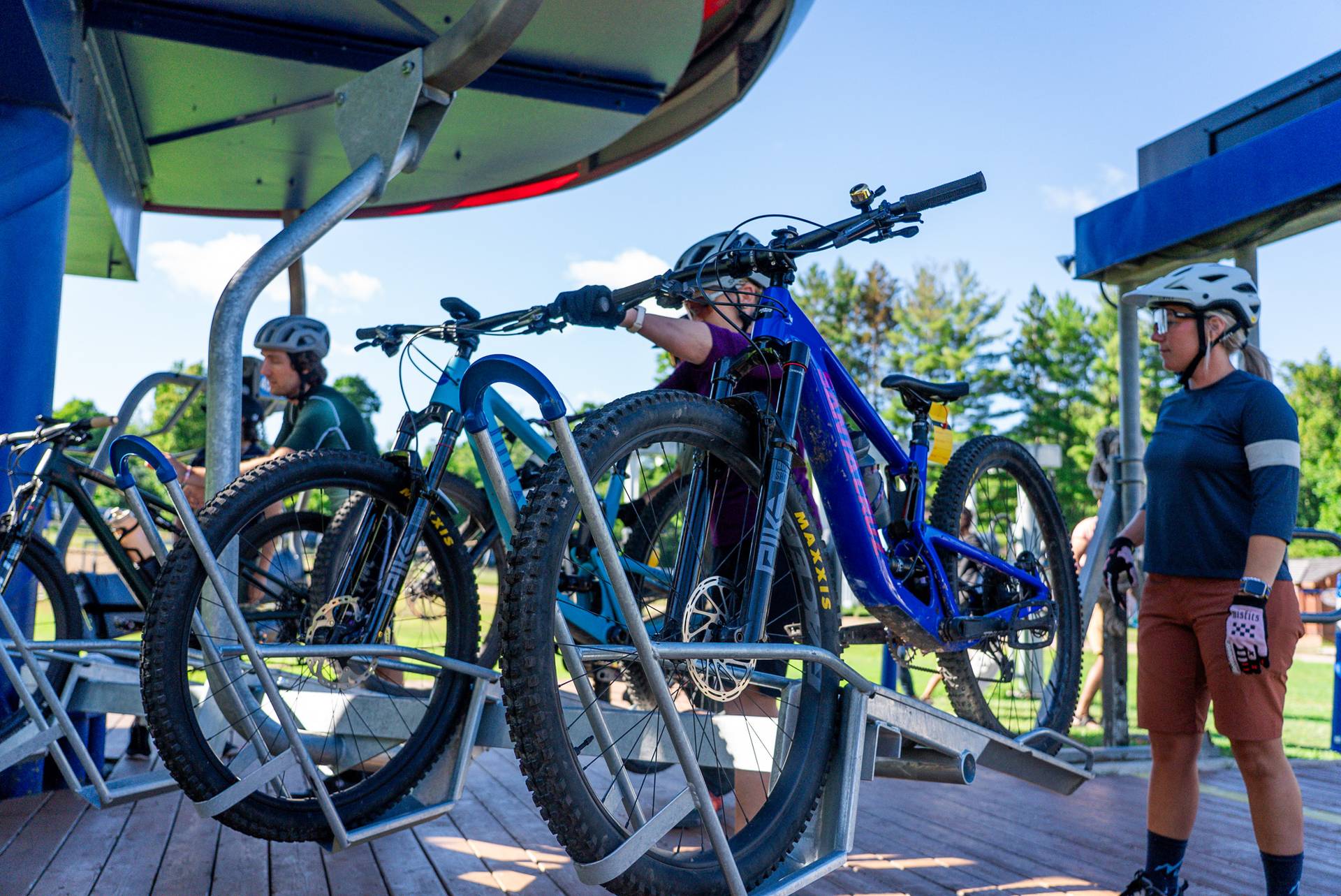 people putting bikes on rack