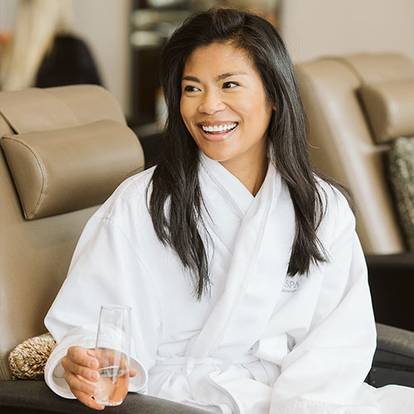 Woman in pedicure seat with glass of champagne at The Spa at Boyne MOuntain