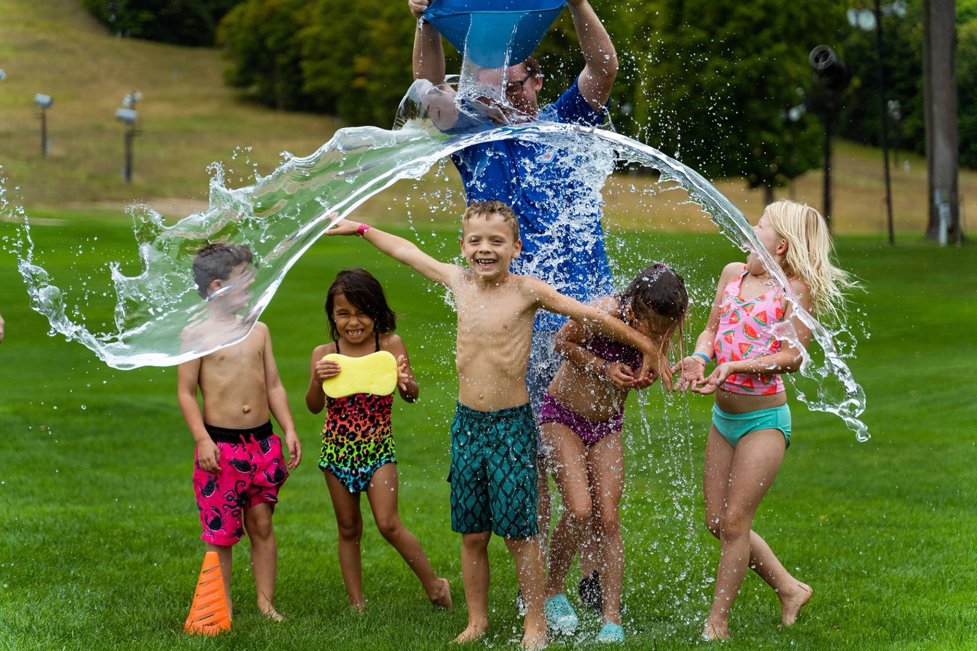Young children getting splashed by a bucket of water