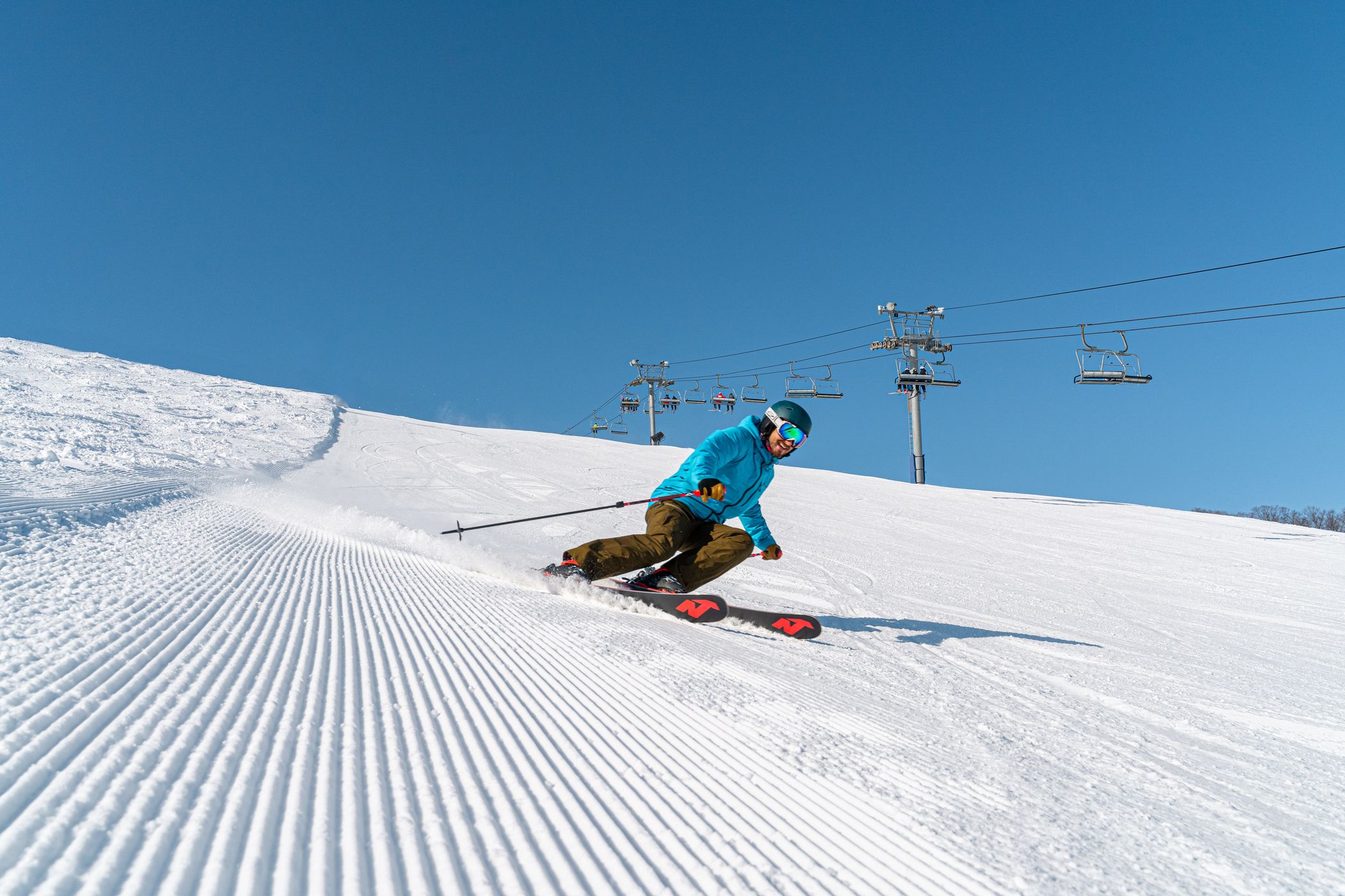 skier ripping down meadows on fresh groomed snow