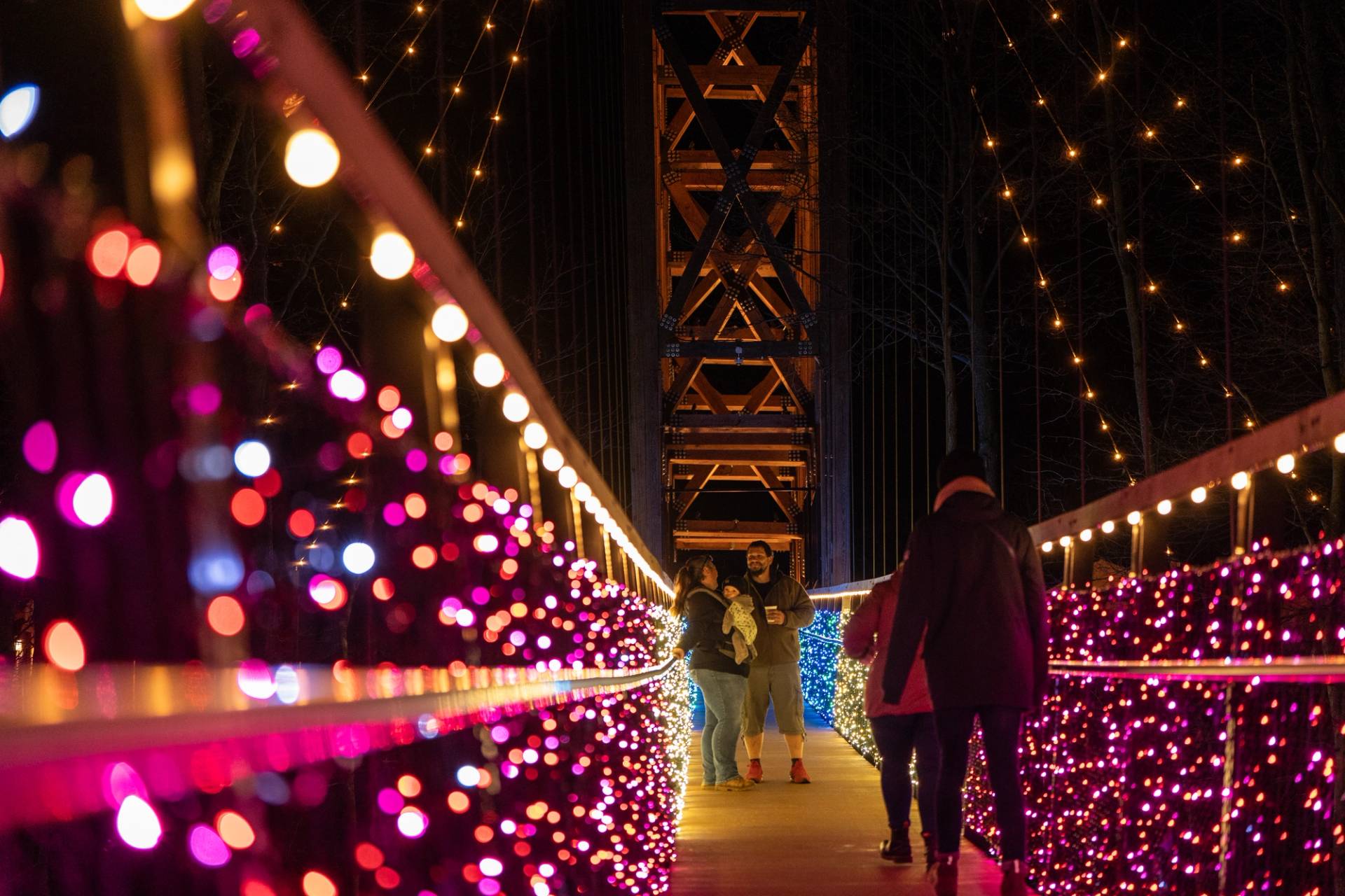 Guests walking across SkyBridge Michigan covered in twinkle lights