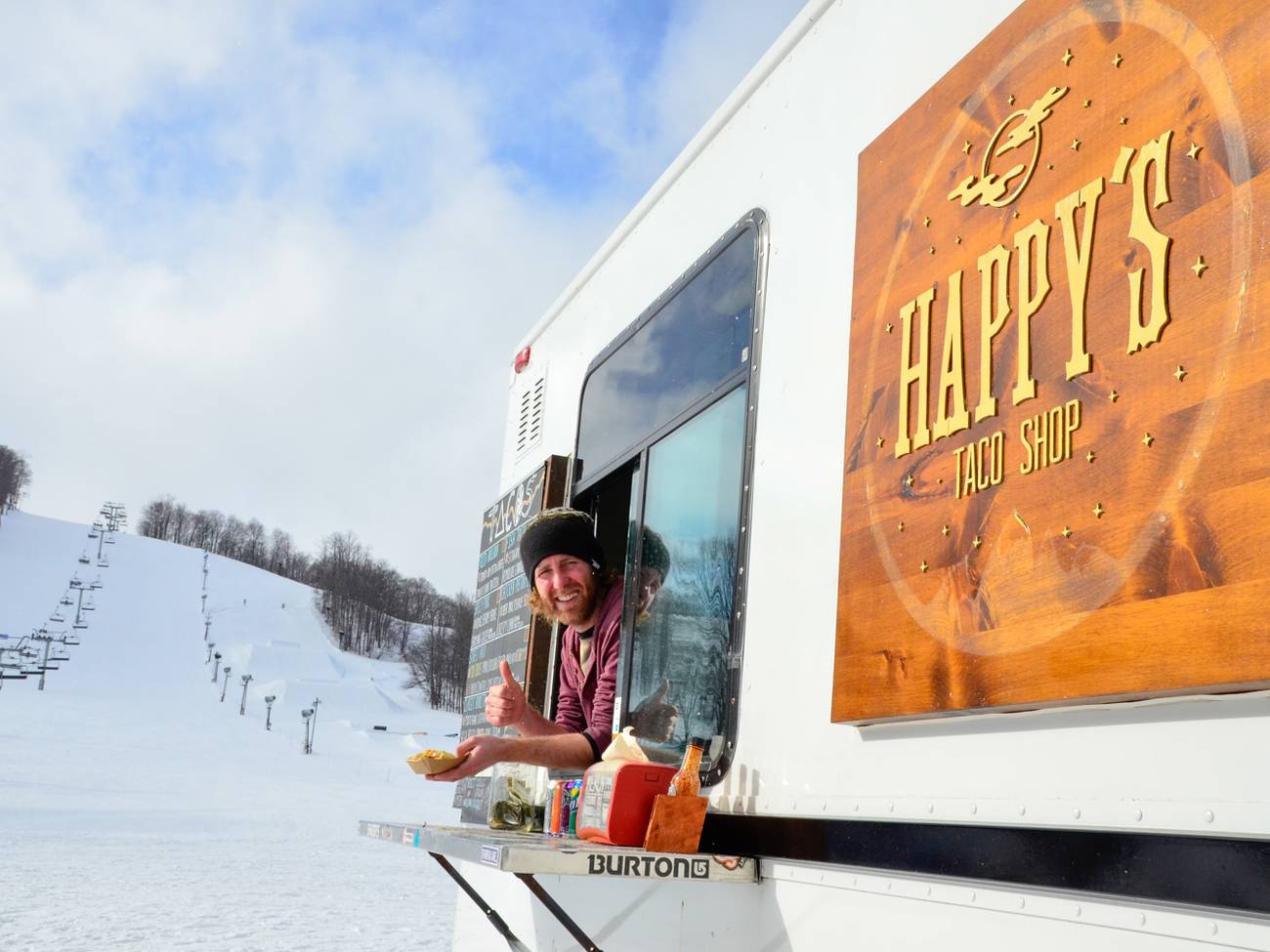 Guy looking out from the Happy's Taco Truck giving thumbs up