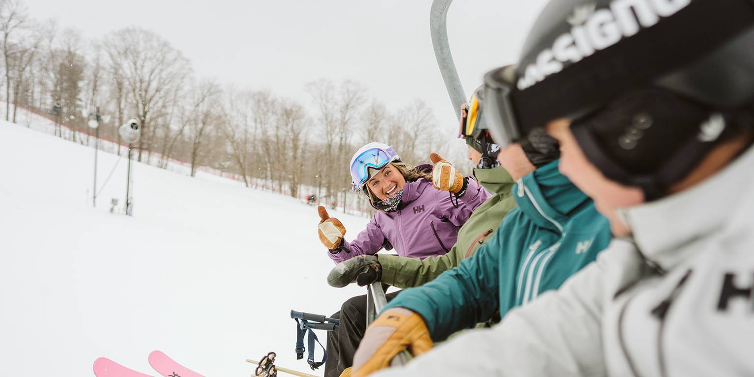 skiers on mountain express lift