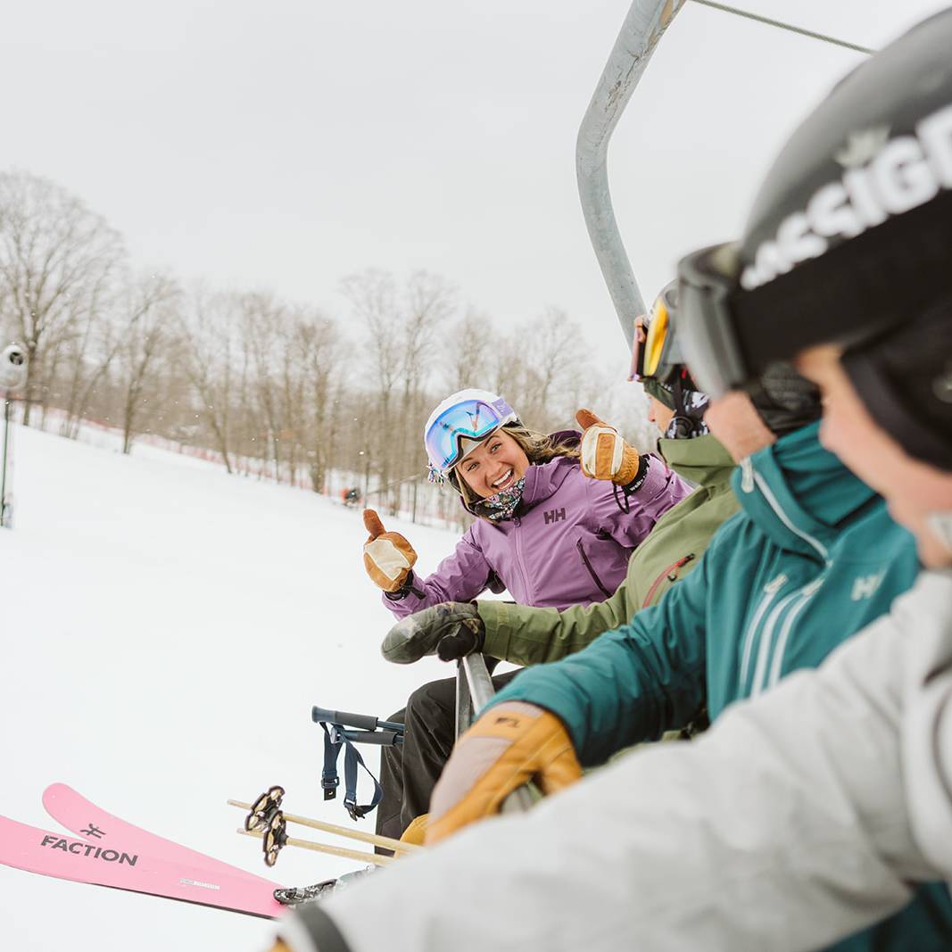 Group of people on the lift giving thumbs up