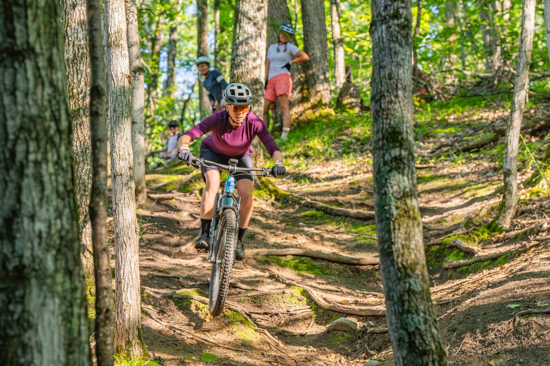 Woman mountain biking through the woods