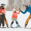 Family giving high fivesw on the slopes