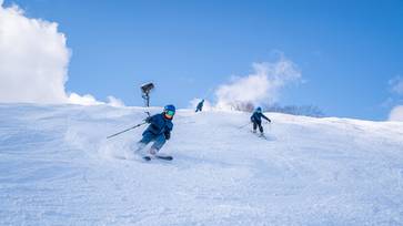 Brothers skiing down Meadows together in matching suits