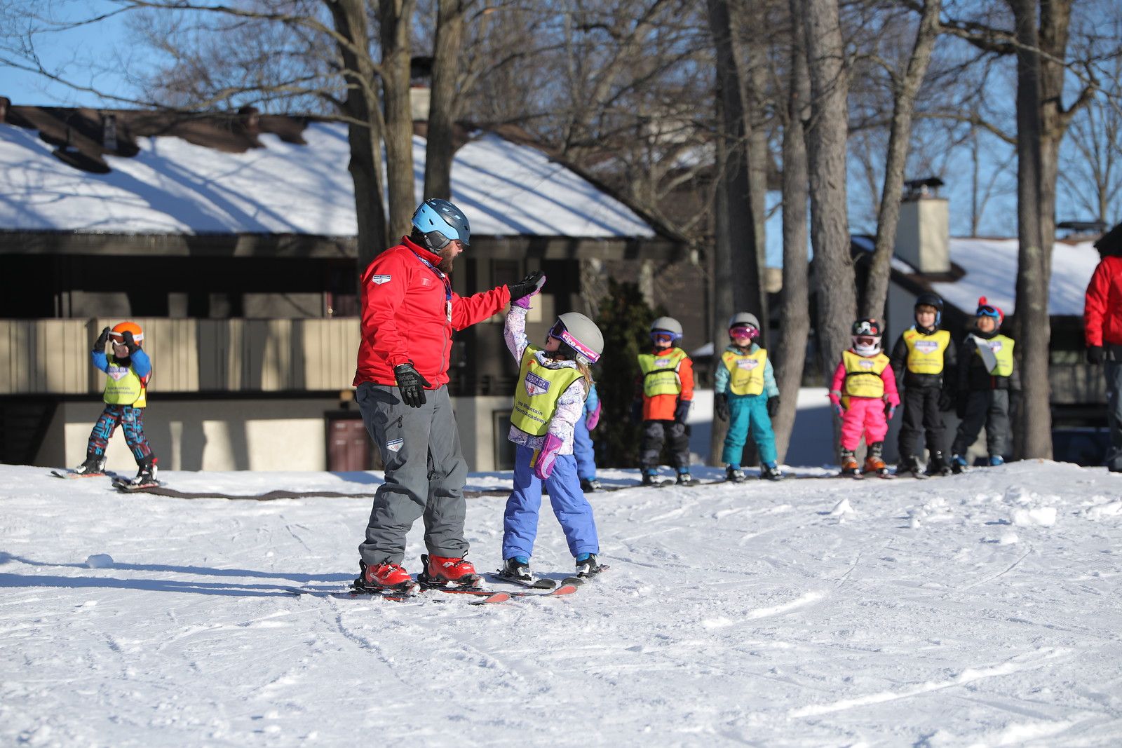High five giving to ski instructor to student