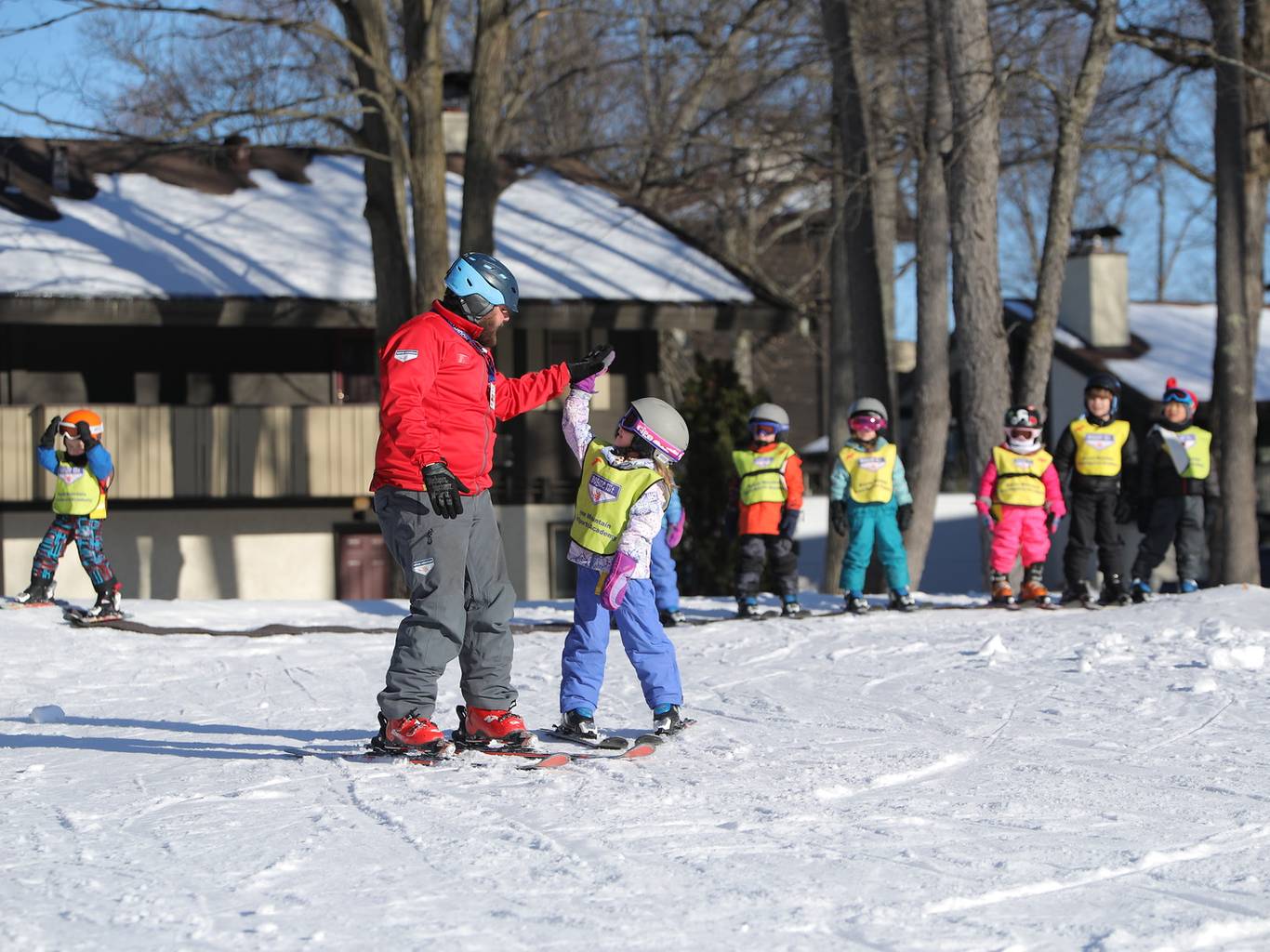 High five giving to ski instructor to student