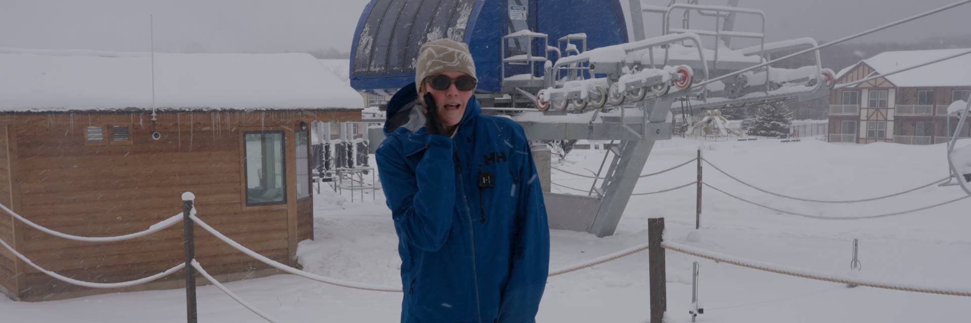 Woman pretending to whisper in front of chairlift