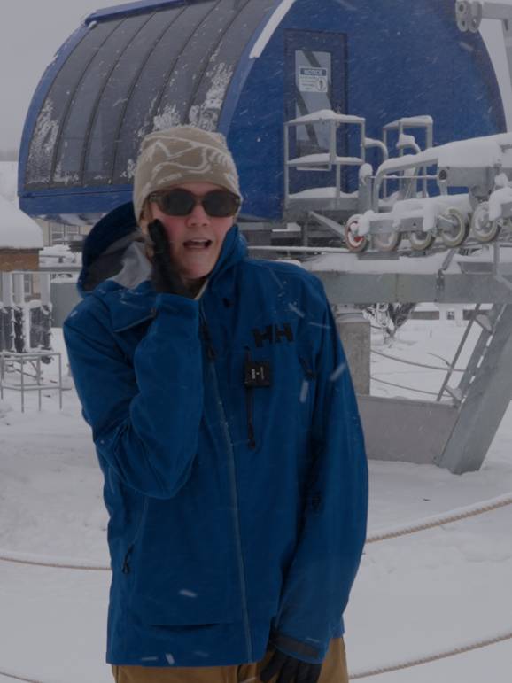 Woman pretending to whisper in front of chairlift