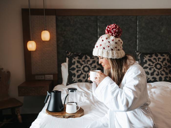 Woman in a robe sitting in a Chalet Edelweiss room