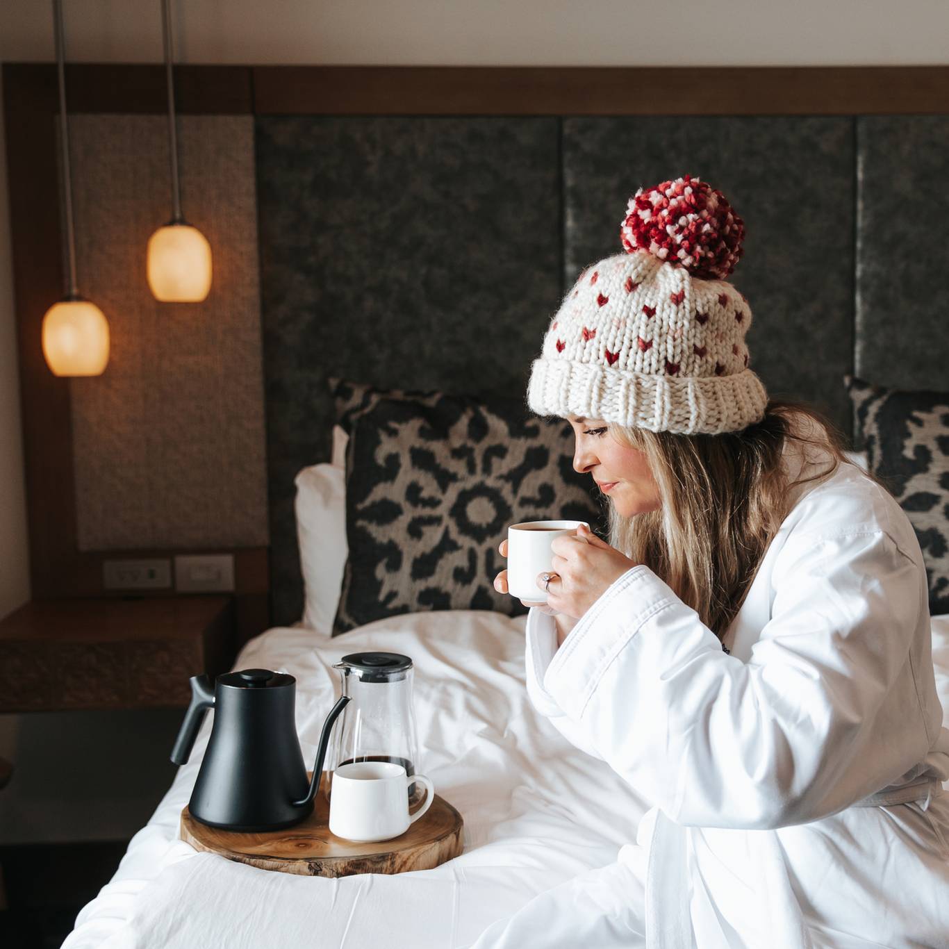Woman sitting on bed in Chalet Edelwiess
