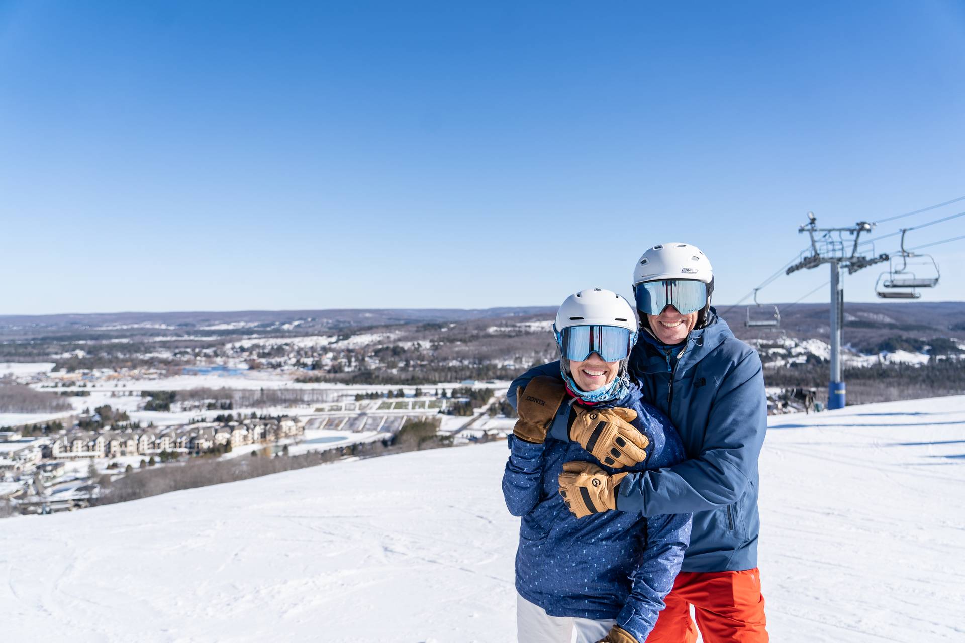 couple smiling in ski gear at the top of boyne mountain