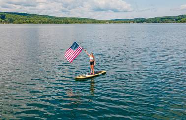 person holding American flag on paddleboard