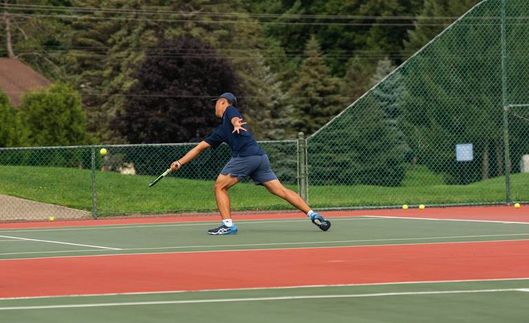 Guy running to hit a tennis ball