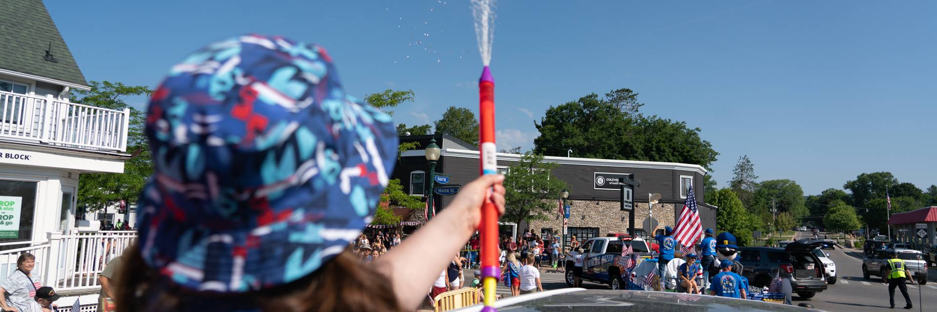 Person using squirt gun in 4th of july parade float