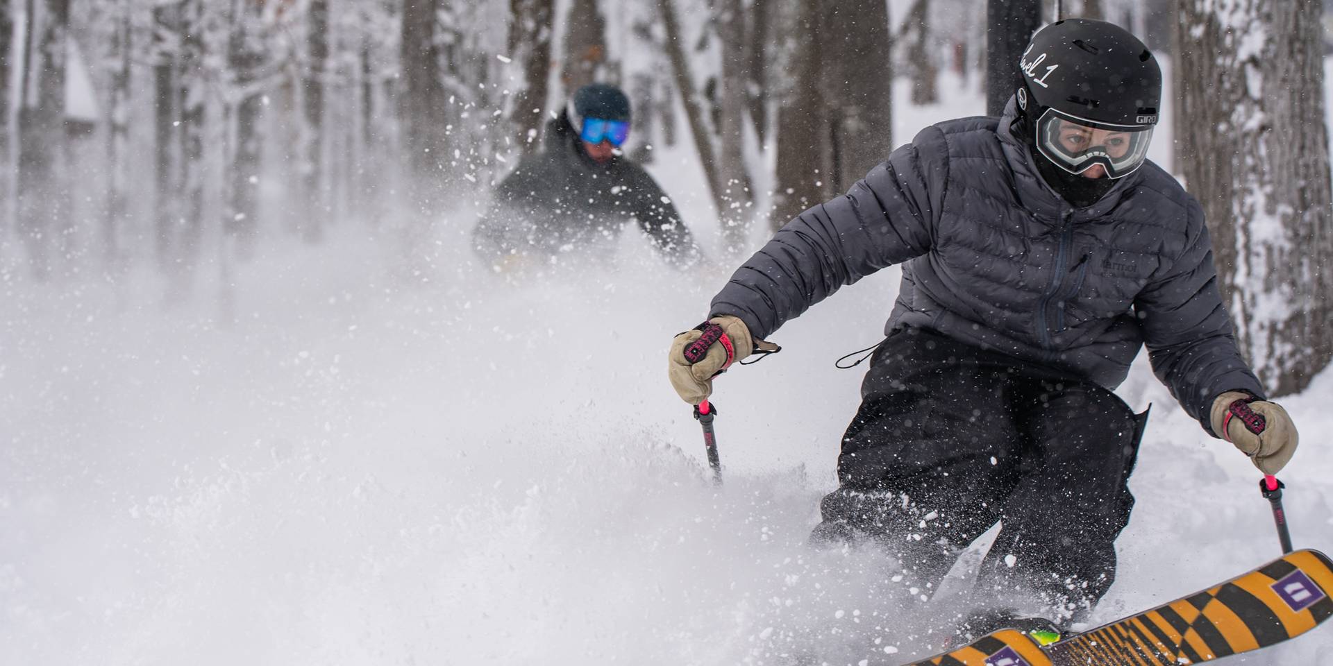 two skiers ripping through powder
