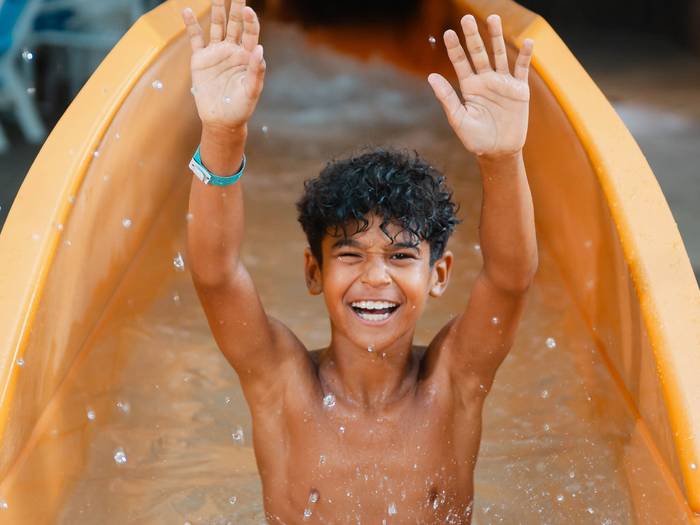 boy hands up at waterpark