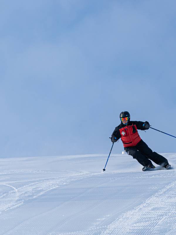 Ski Patrol member riding down mountain