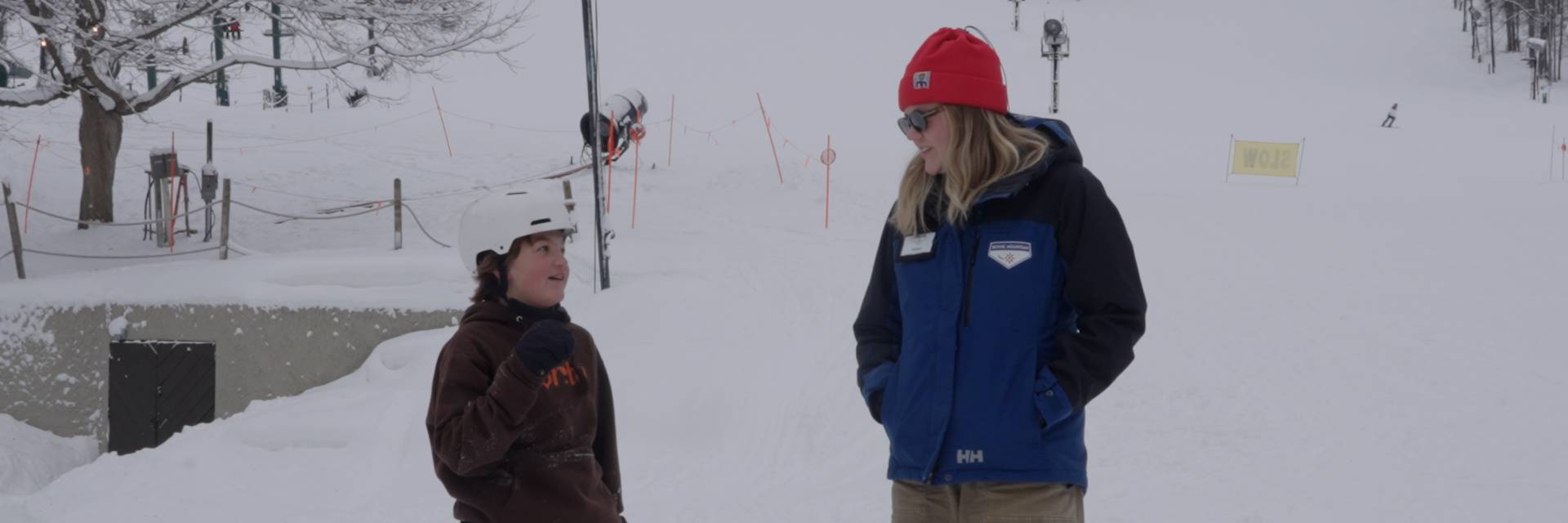 Woman and child standing in front of ski slope